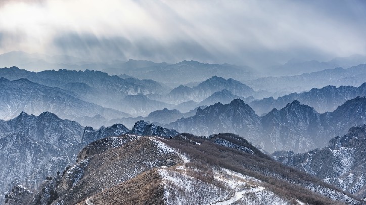 阳光穿透云层洒在蒲洼乡雪山上